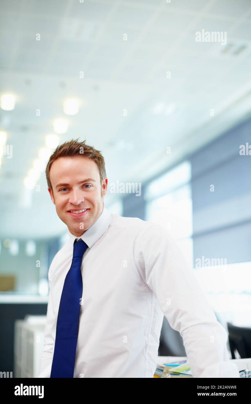 Positive hell be successful. Handsome young male executive in his workplace. Stock Photo