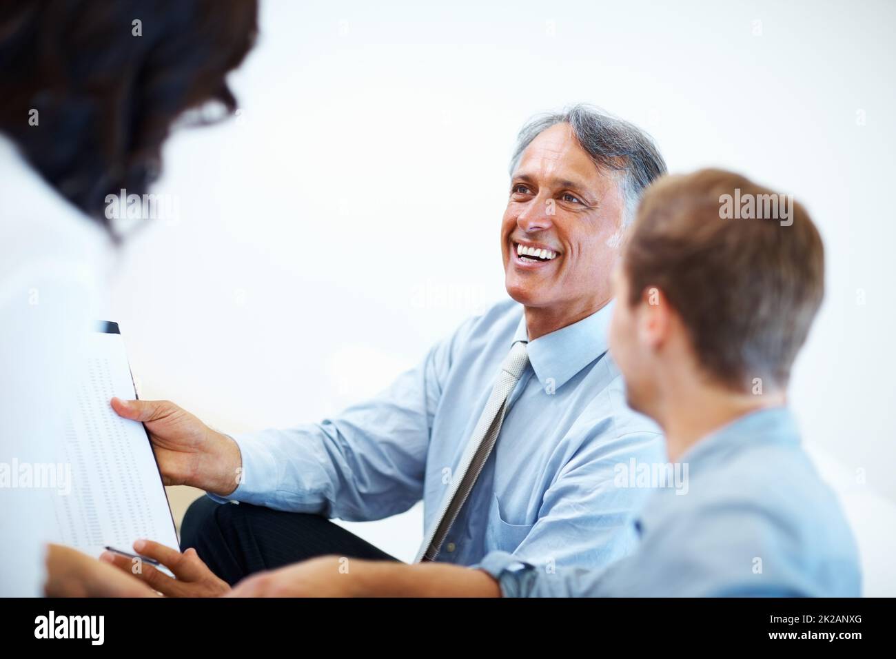 Male advisor with clients. Happy male advisor showing financial plan to clients. Stock Photo