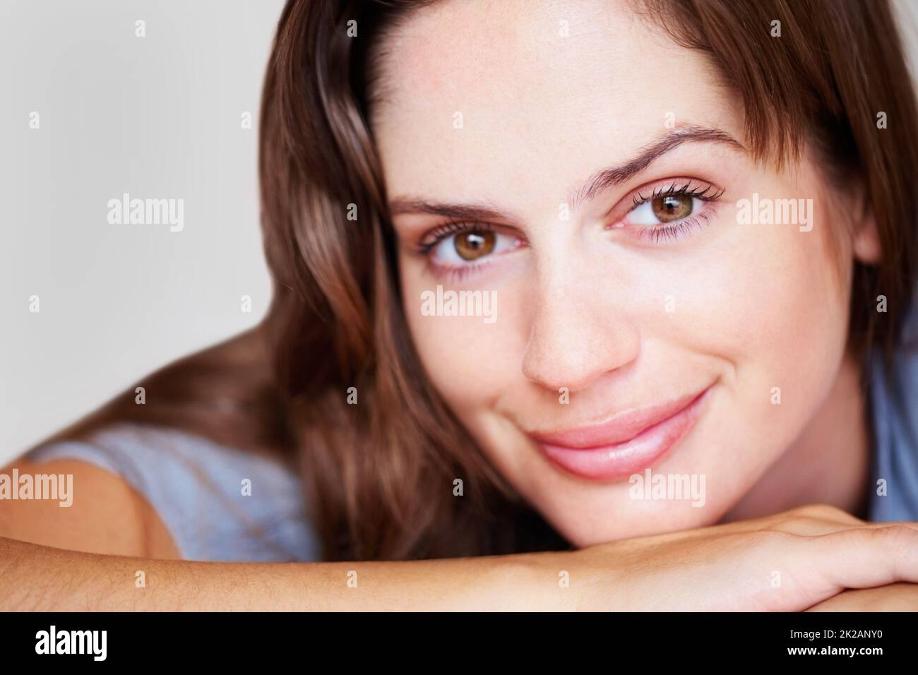 Closeup of an elegant female brunette with a soft smile. Closeup portrait of a lovely female brunette with a charming smile. Stock Photo