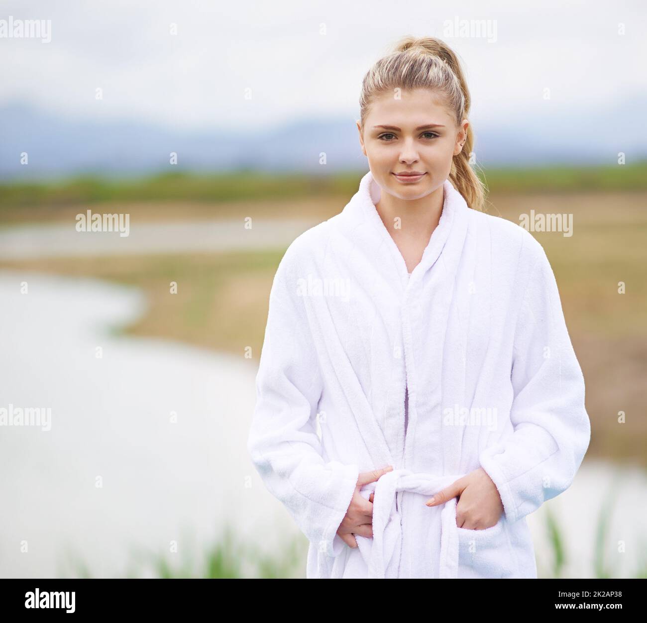 Enjoying a luxurious getaway. Shot of a young woman wearing a robe standing in the outdoors. Stock Photo