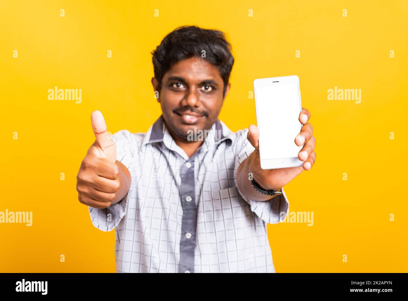 black man smile showing a mobile smartphone blank screen and finger thumb up Stock Photo