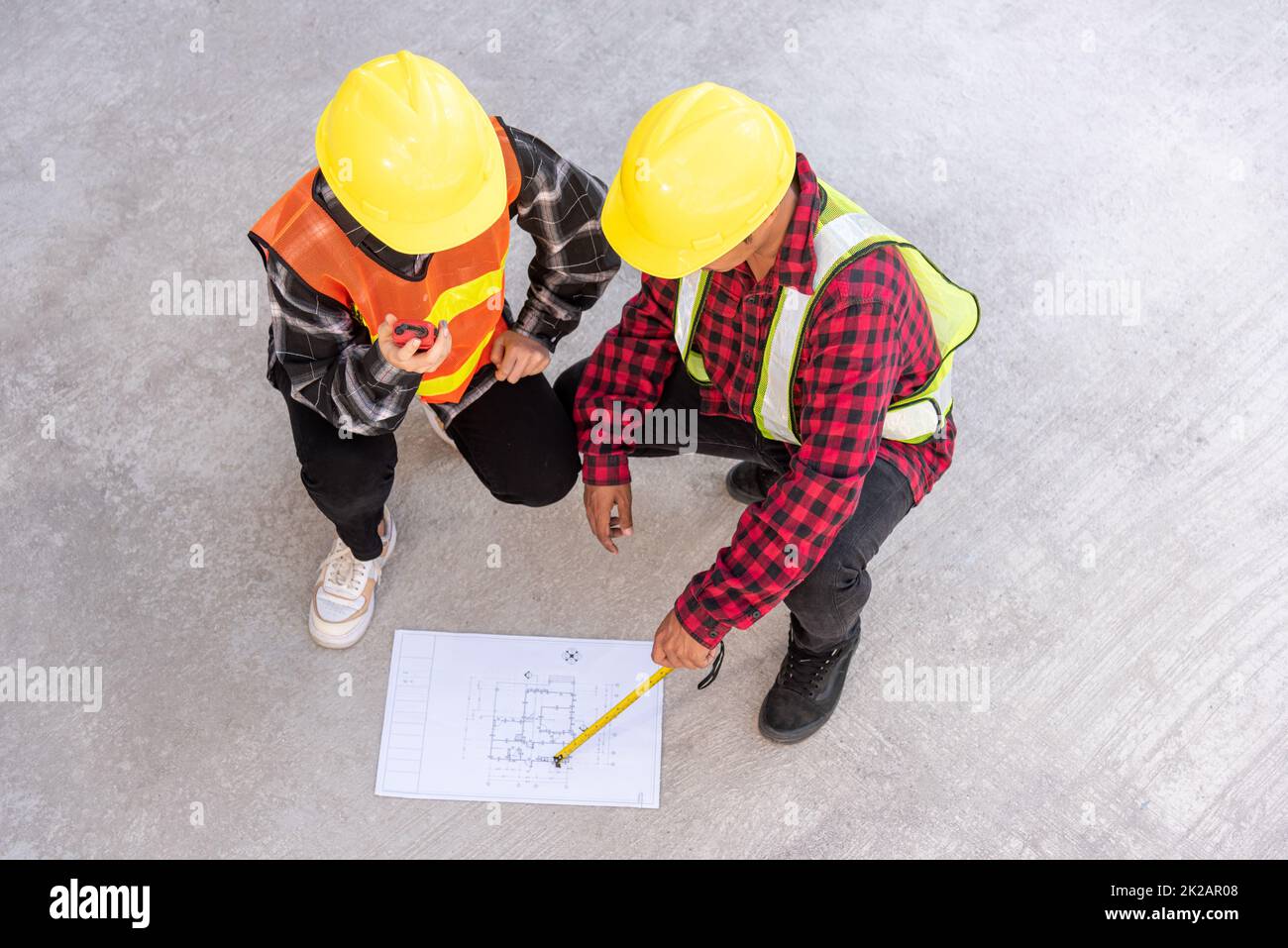 Architect and client discuss help create plan with blueprint of the building at construction site floor Stock Photo