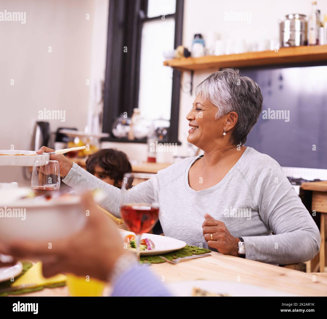 Theres nothing like a home-cooked meal. A happy senior woman sharing a meal with her family at home. Stock Photo