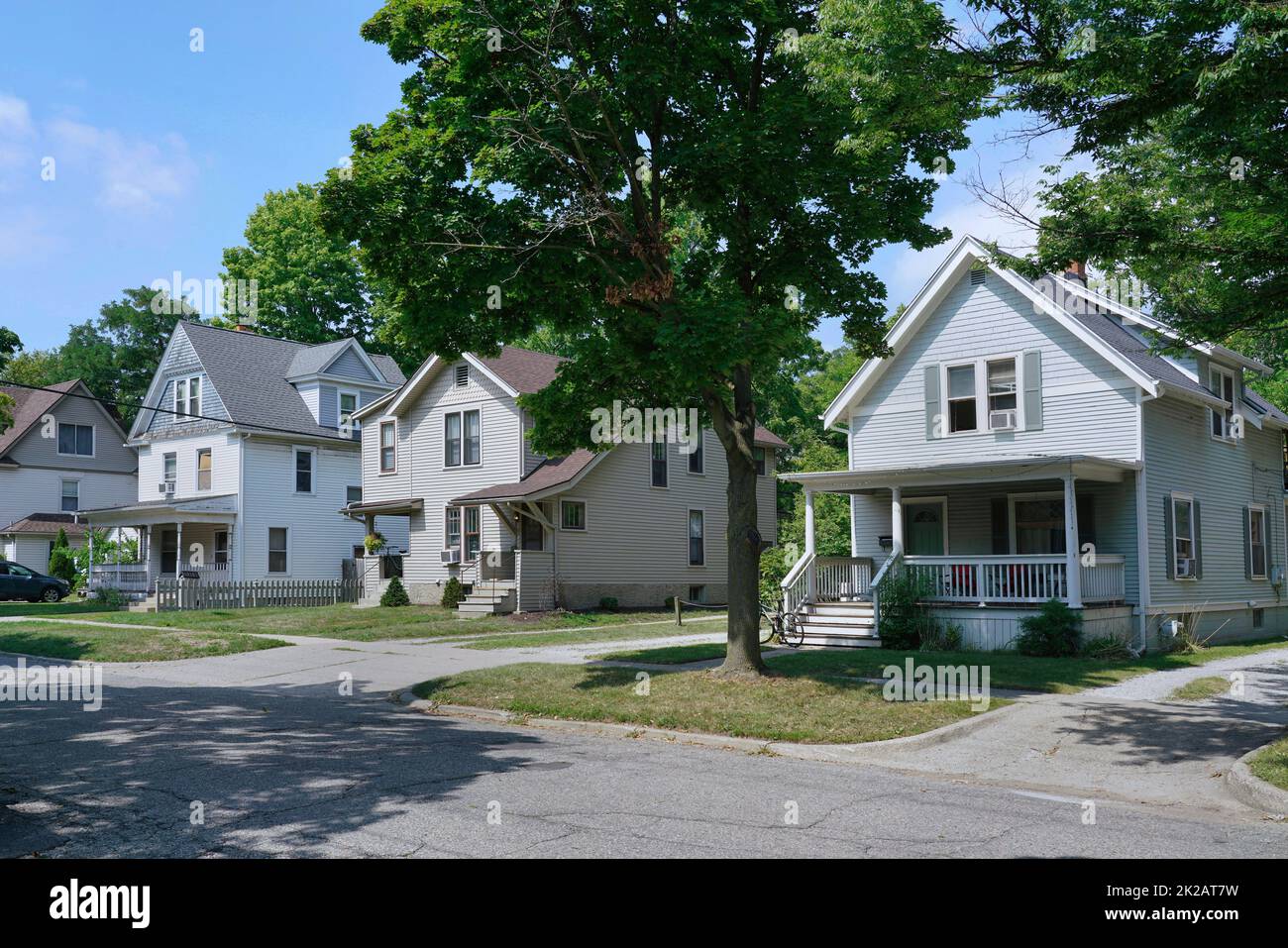 Residential street with traditional detached two story houses covered in siding or clapboard Stock Photo
