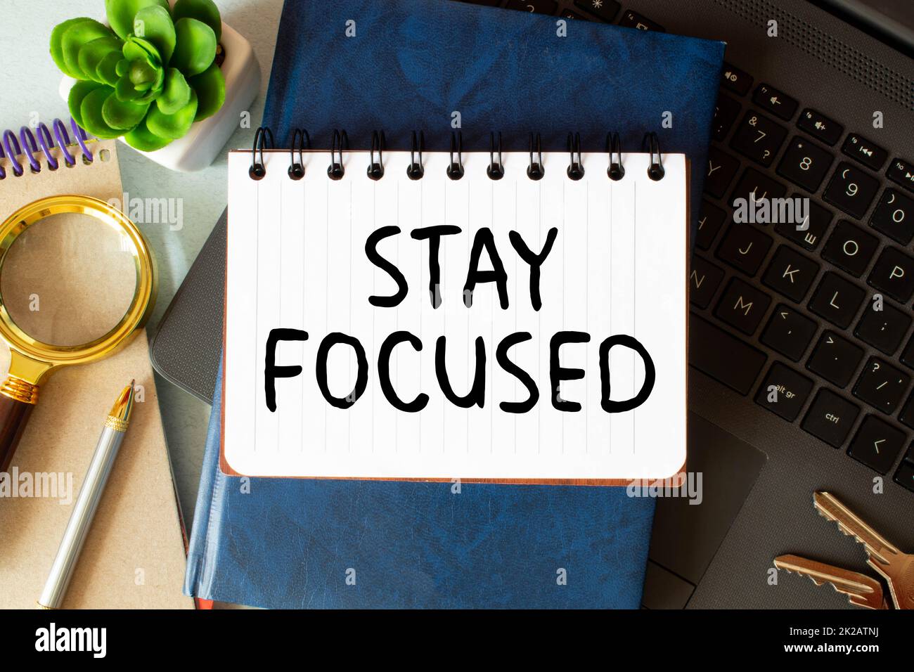 STAY FOCUSED man hand notebook and other office equipment such as computer keyboard. Stock Photo