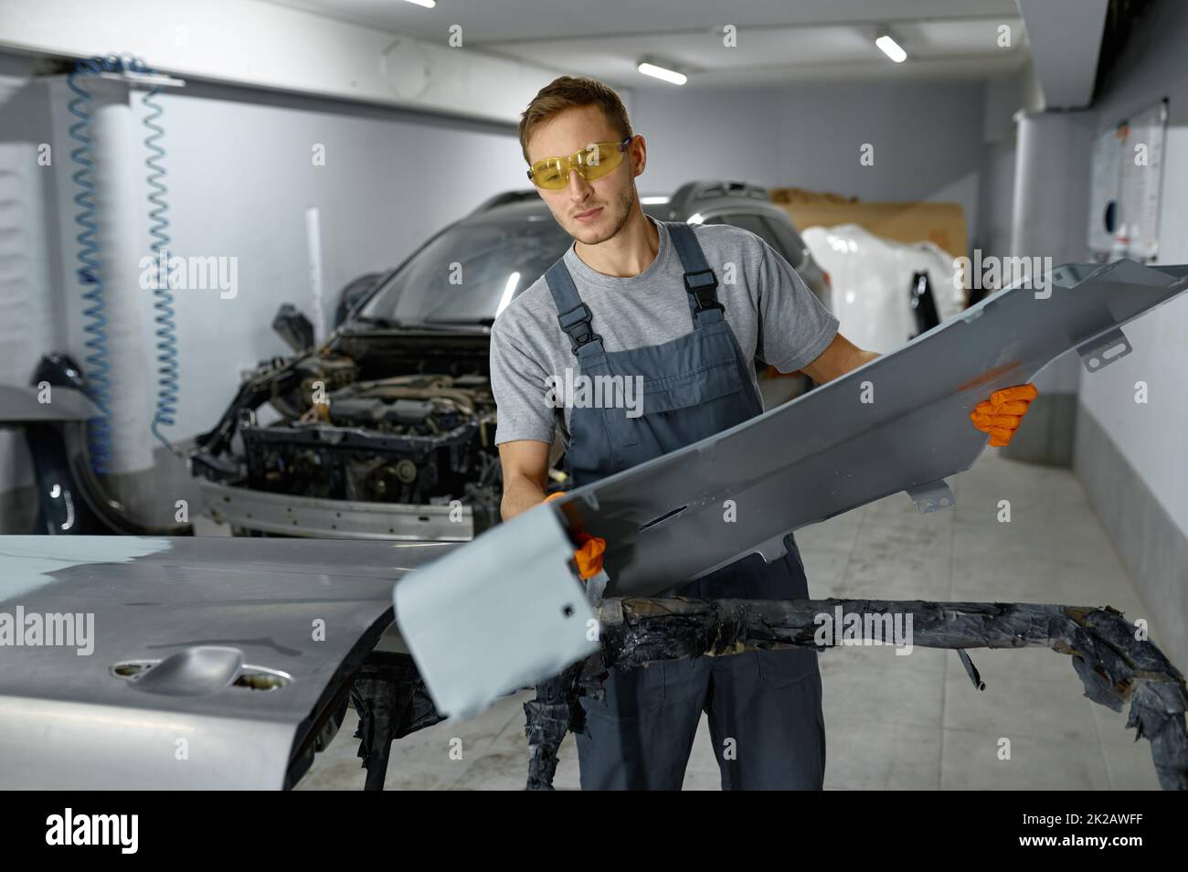 Mechanic engaged auto part assembly after painting Stock Photo