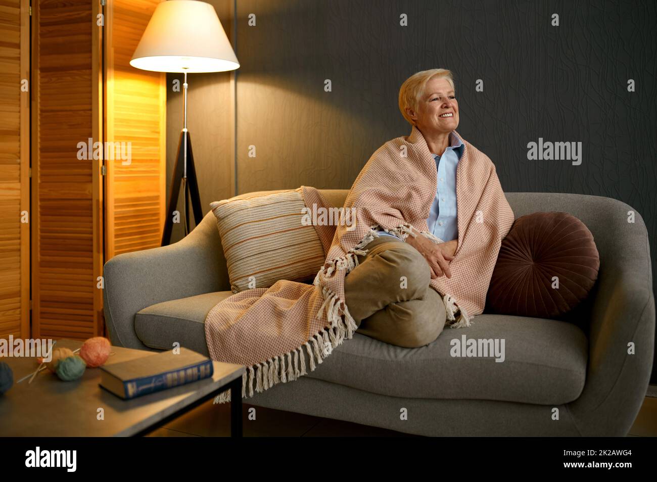 Satisfied old woman wrapped in blanket relaxing Stock Photo
