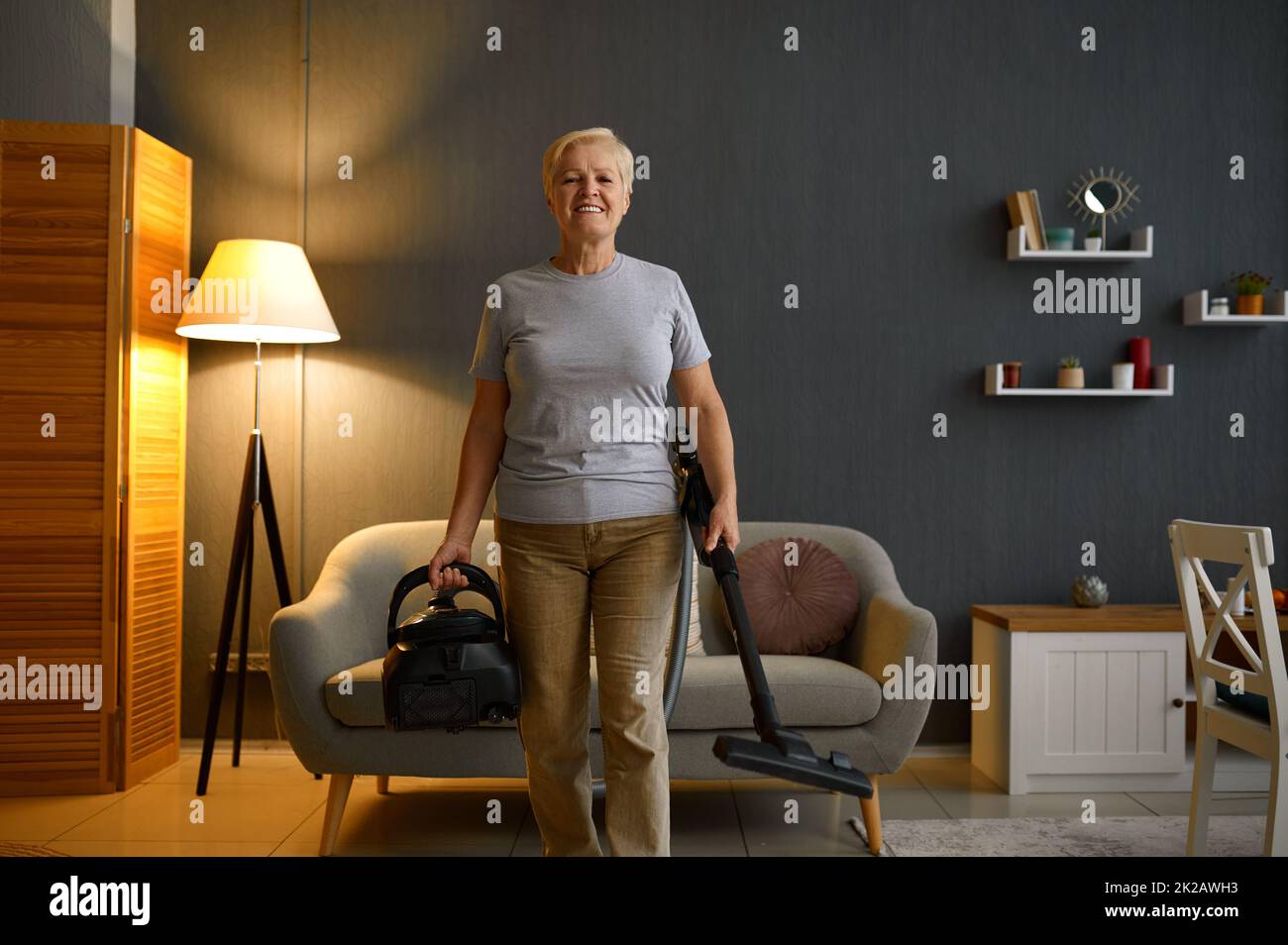 Happy elderly woman cleaning home Stock Photo Alamy