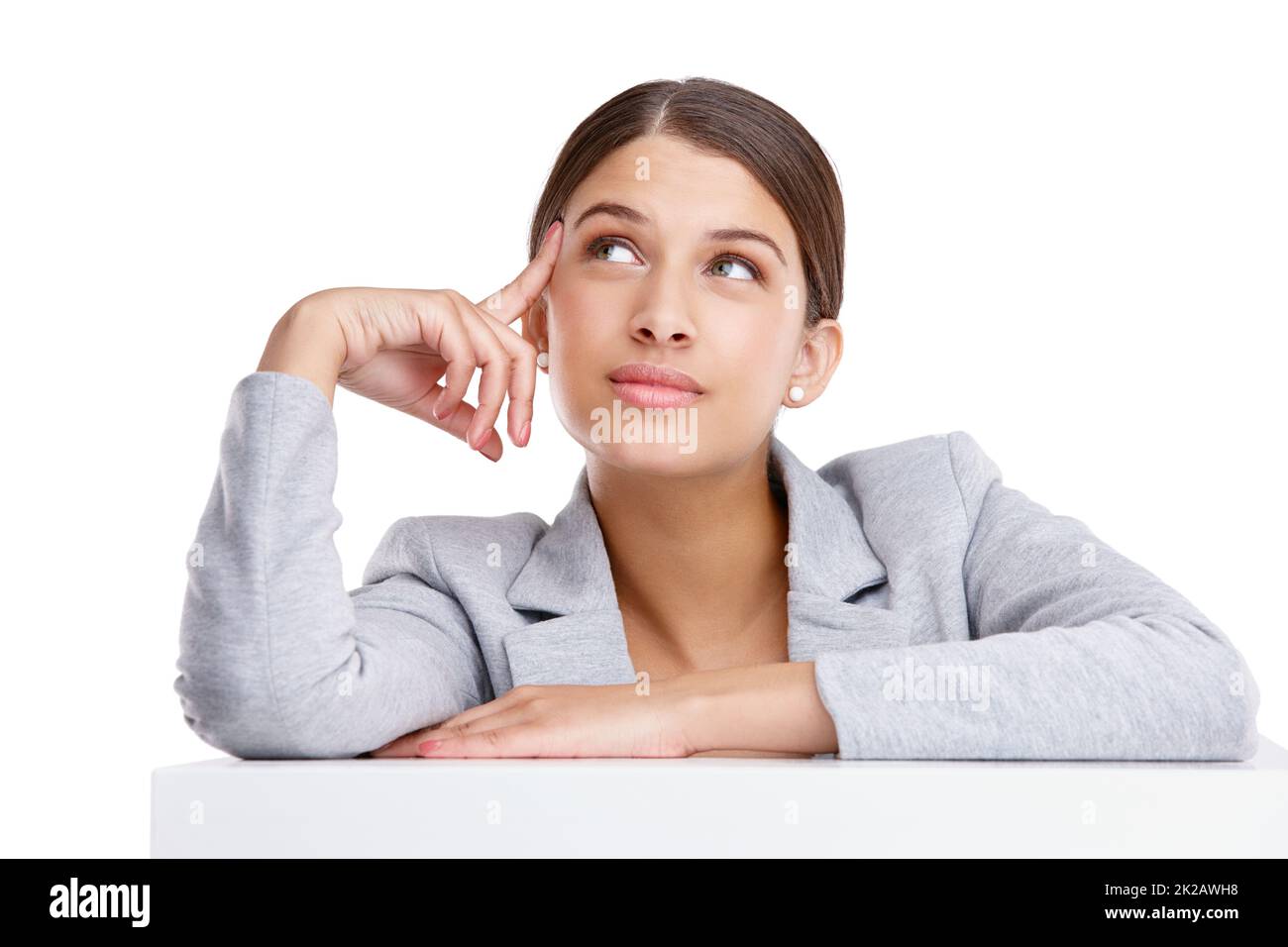 If you dream it you can do it. Studio shot of a beautiful young woman resting on a table against a white background. Stock Photo