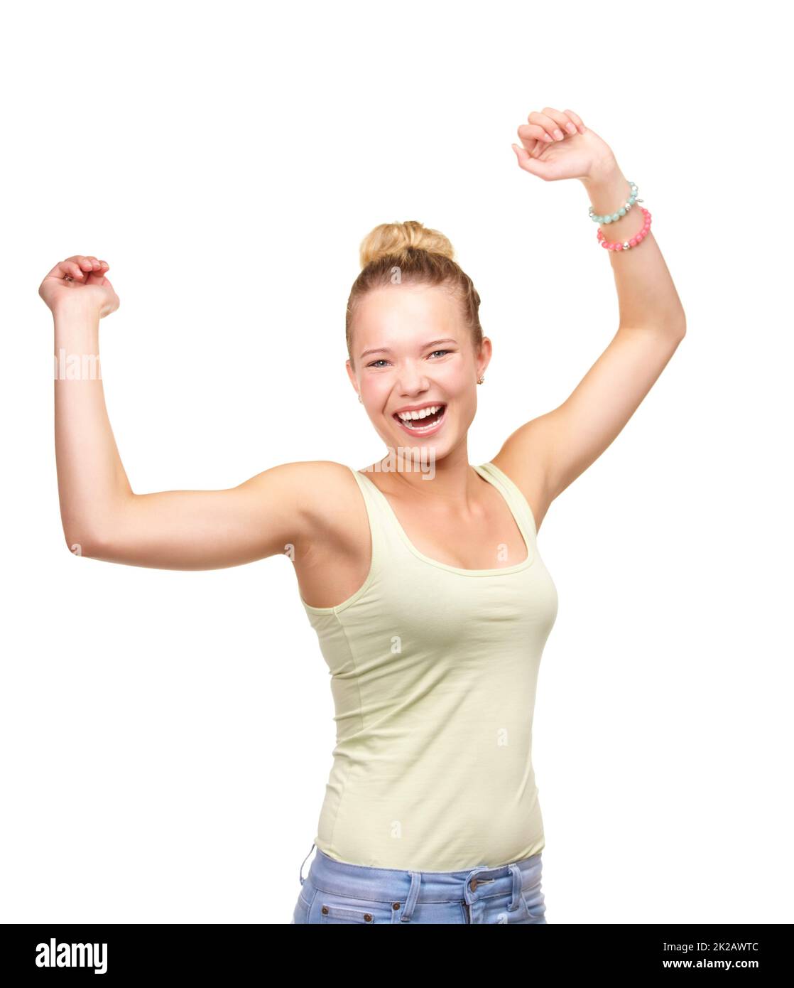 Dance fever. A pretty smiling teenage girl standing with arms raised in