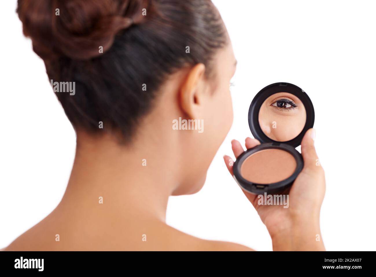 I see you. Shot of a womans eye reflecting on her compact mirror. Stock Photo