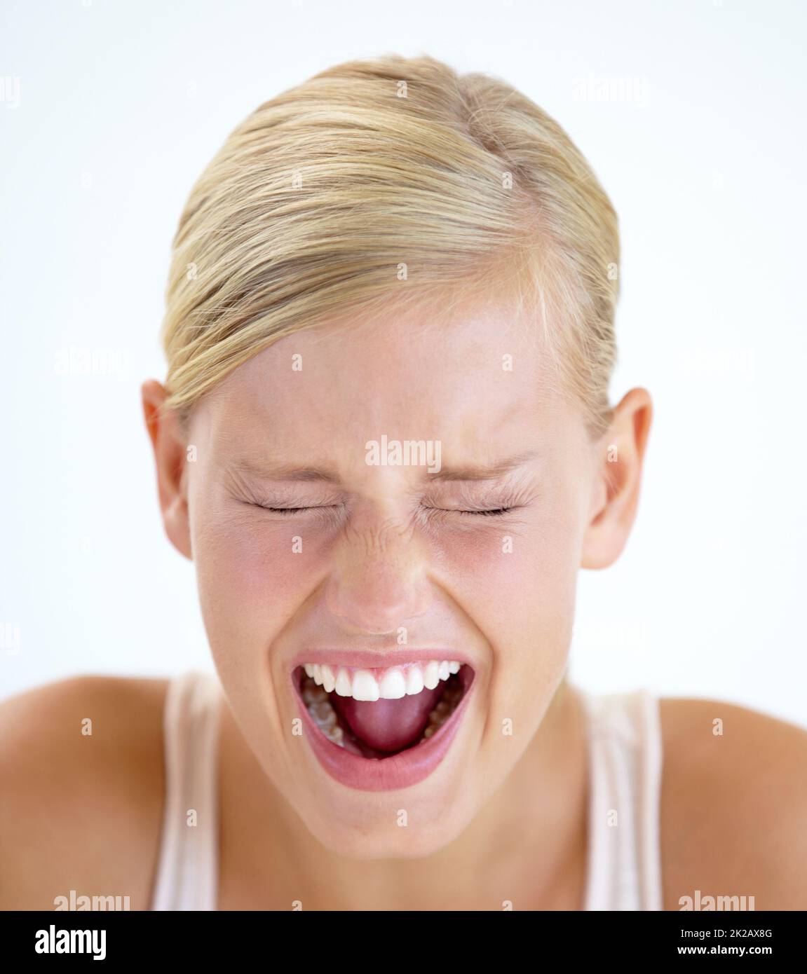 Venting her emotions. A frightened young woman shrieking with her eyes closed. Stock Photo