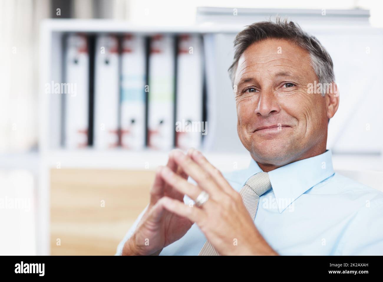 Your idea is brilliant. Portrait of a respected business manager sitting at his desk with steepled hands. Stock Photo