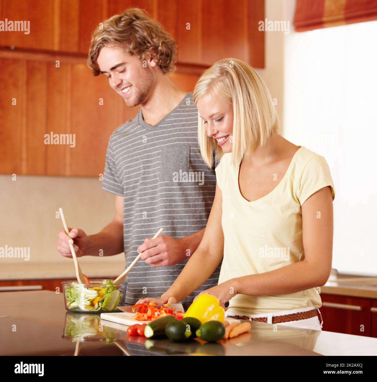 Cooking together. A young couple making dinner in the kitchen. Stock Photo