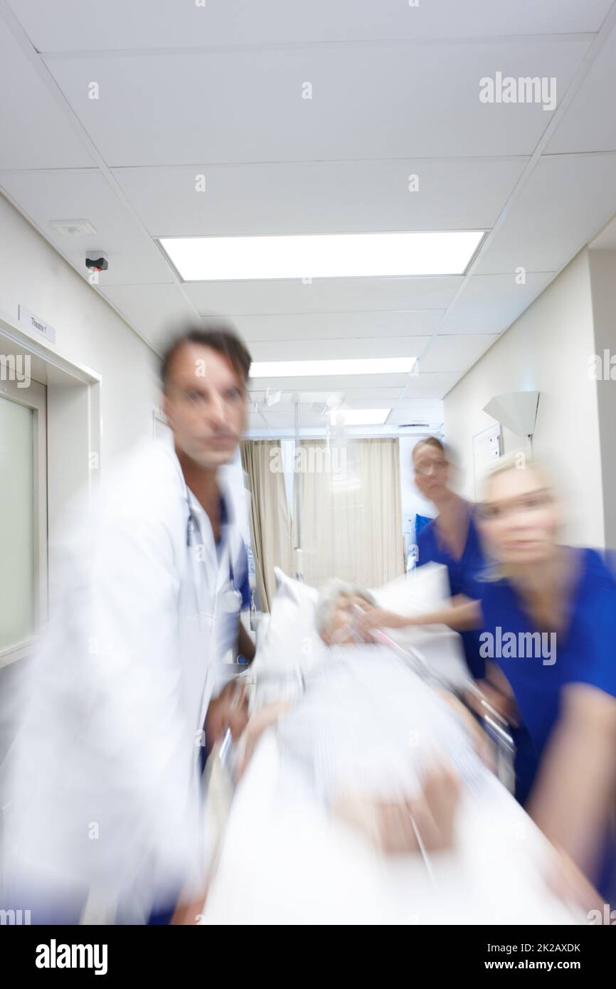 A group of doctors rushing a patient down the corridor Stock Photo Alamy