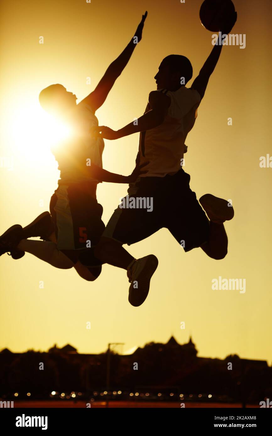 Clash of the Titans. Two basketball players playing at sunset. Stock Photo