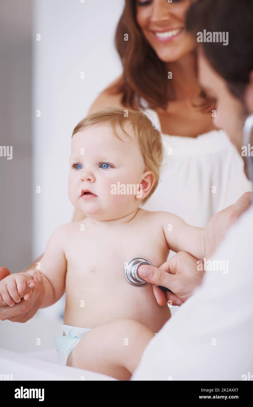 No tears today. A mother standing by as her baby daughter is being examined by a pediatrician. Stock Photo
