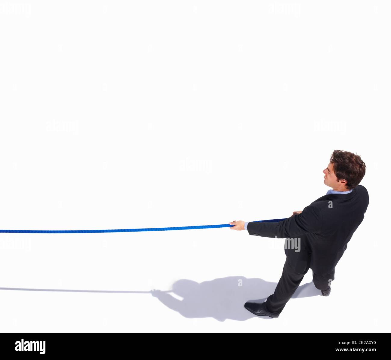Top view of an isolated business man pulling on to a rope. Tug of war - Top view of a young business man pulling on to a rope. Stock Photo