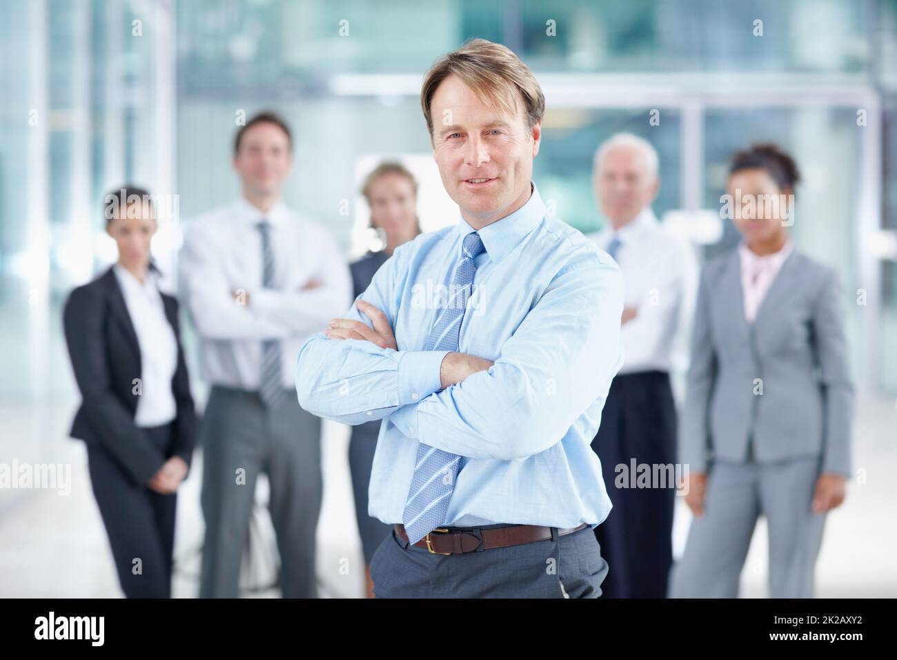 Ive got a great team behind me. Confident mature business executive smiling while standing with his team behind him - portrait. Stock Photo