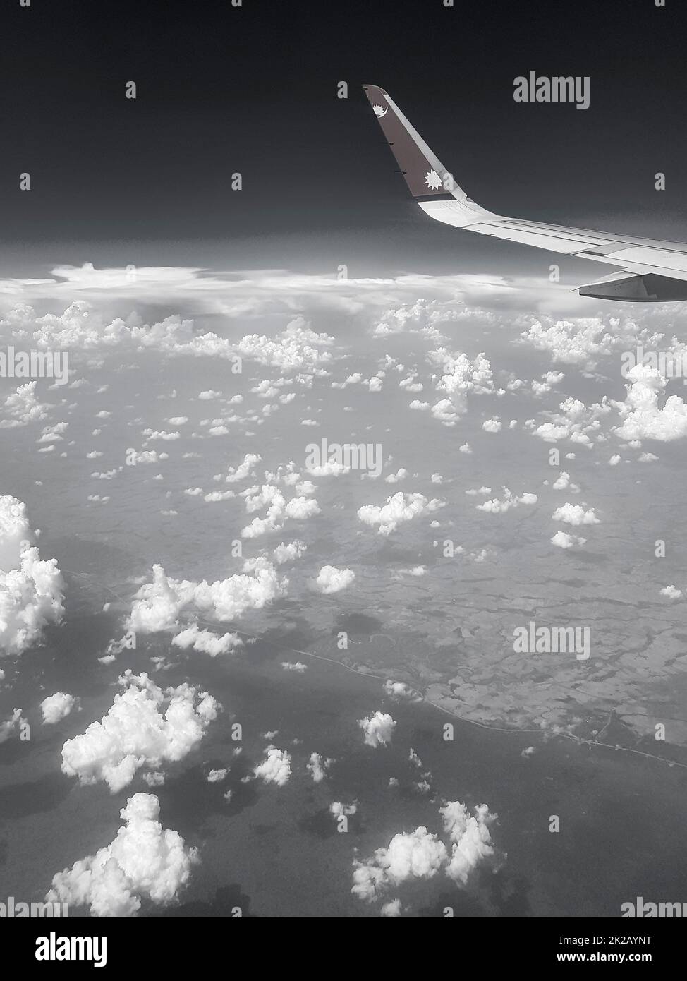 Flying with Nepal Airline above clouds over countryside of Thailand. Stock Photo