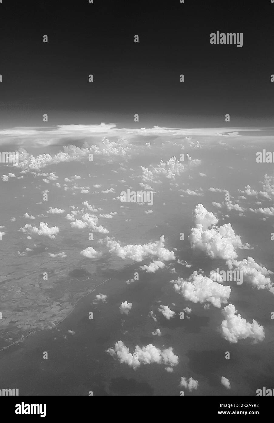 Flying above clouds over countryside of Thailand black and white. Stock Photo