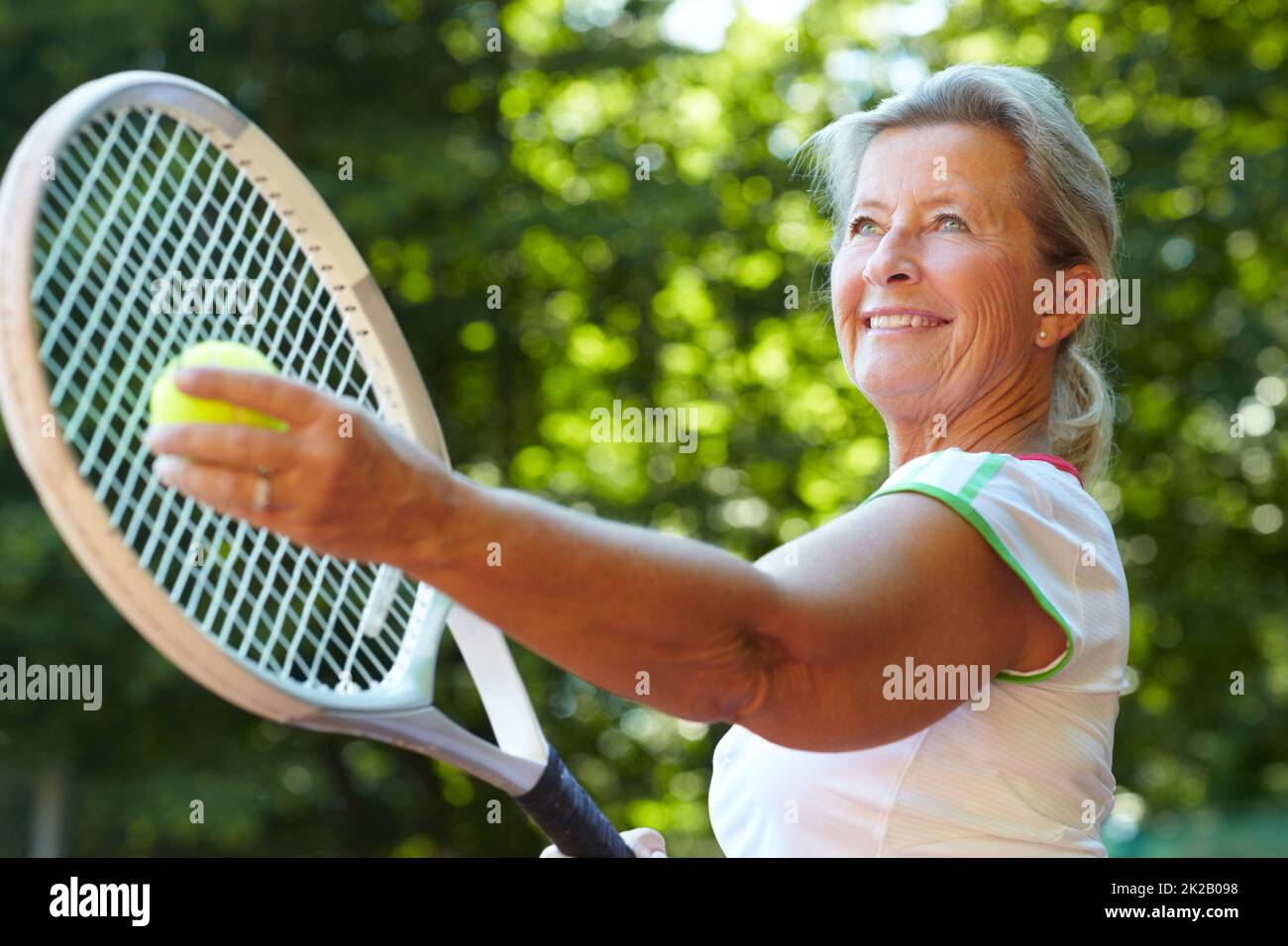 Getting ready to serve Tennis technique. Senior woman preparing to