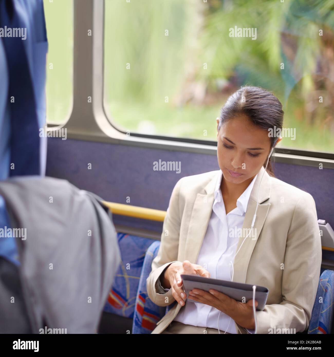 Shes never bored on the bus. Shot of a businesswoman using a digital tablet while commuting on a bus. Stock Photo
