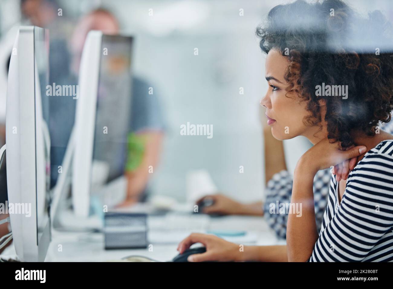 Trouble shooting tech is my specialty. Shot of a young office worker sitting at her workstation in an office. Stock Photo