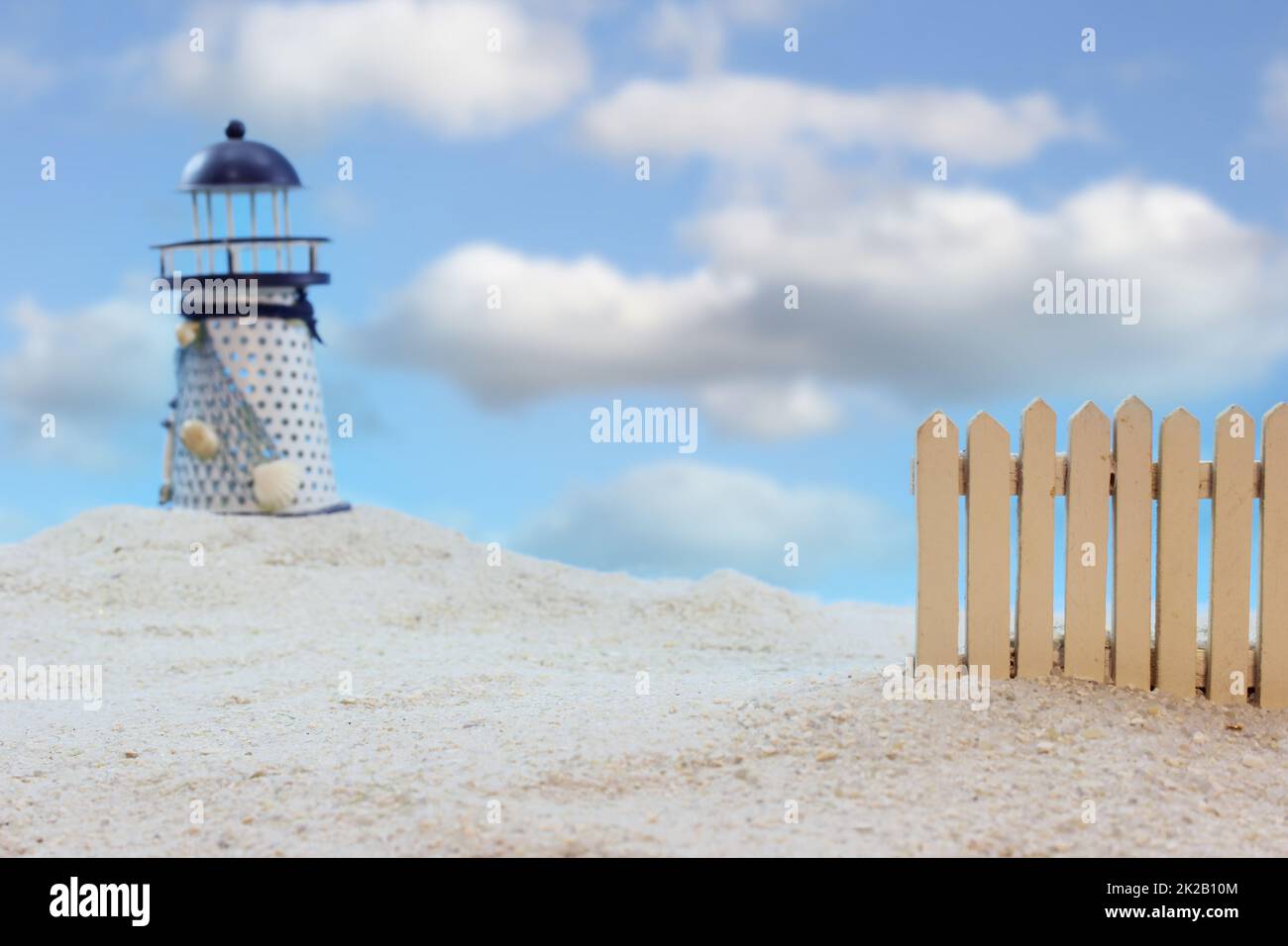 Lighthouse With Pickett Fence and Blue Sky Shallow DOF Stock Photo