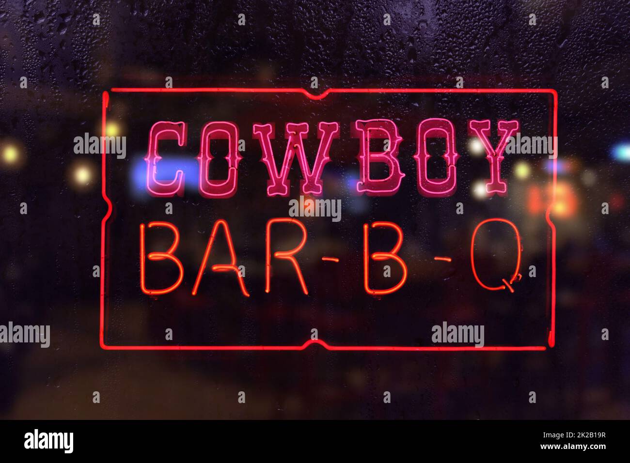 Vintage Cowboy BBQ Neon Sign in Rainy Window Stock Photo