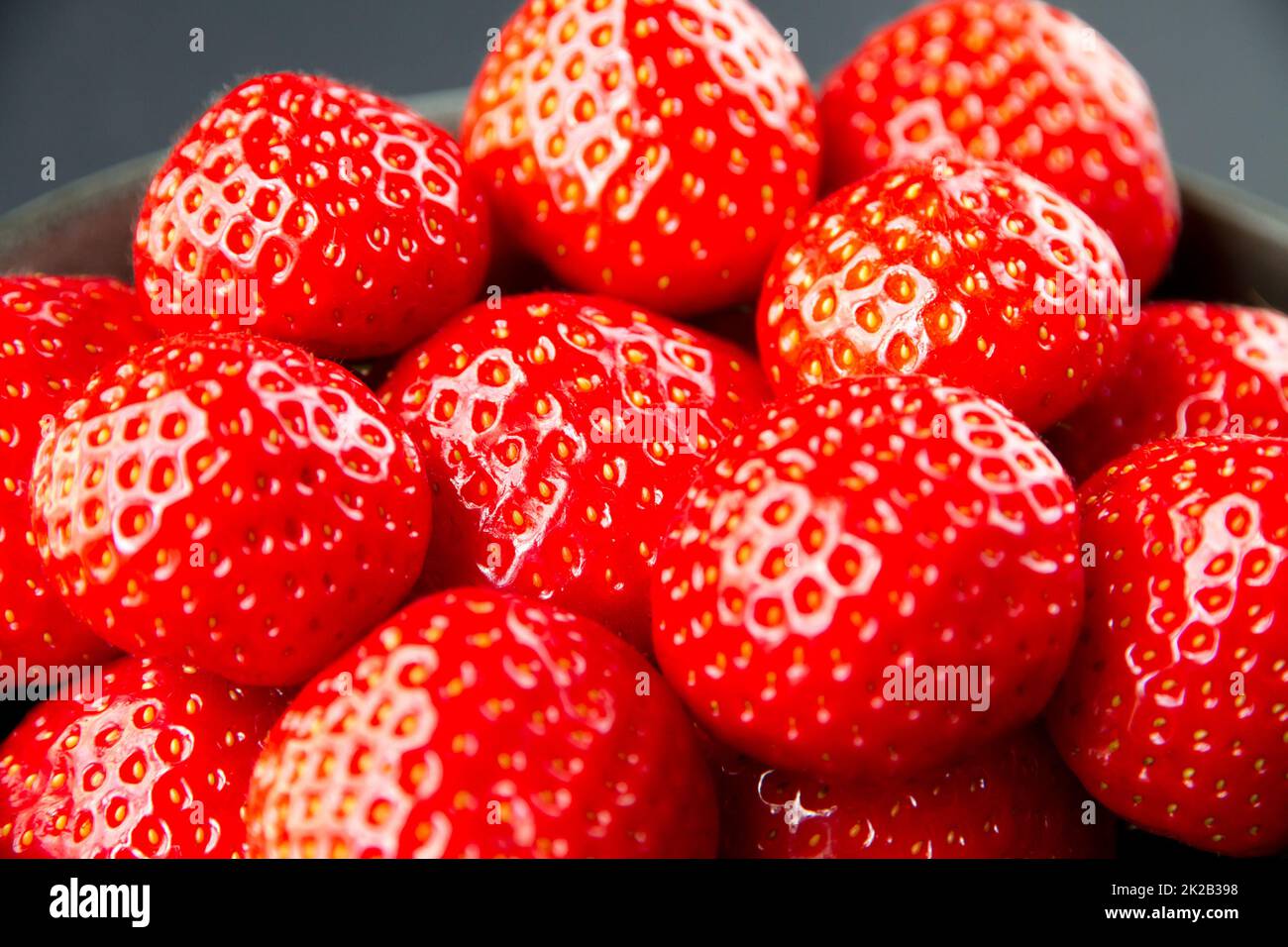 Strawberries in a bowl. Black background Stock Photo - Alamy