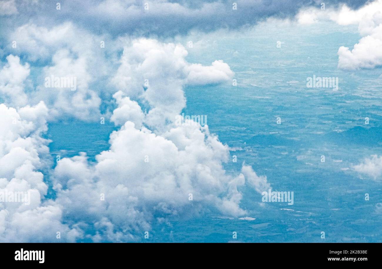 Flying above the clouds over the countryside of Thailand. Stock Photo