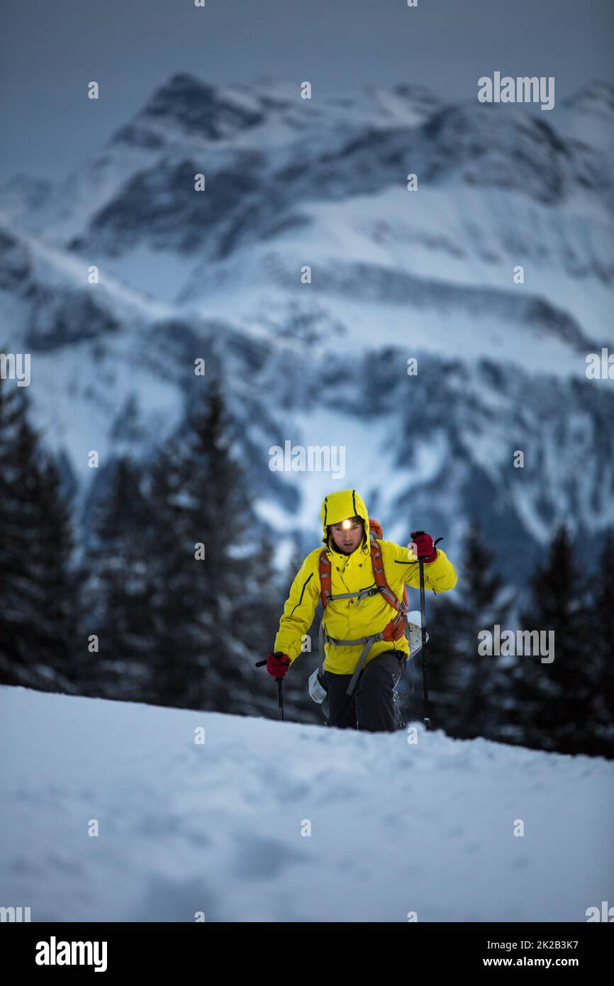 Young man snowshoeing in high mountains, enjoying splendid winter weather with abundance of snow Stock Photo