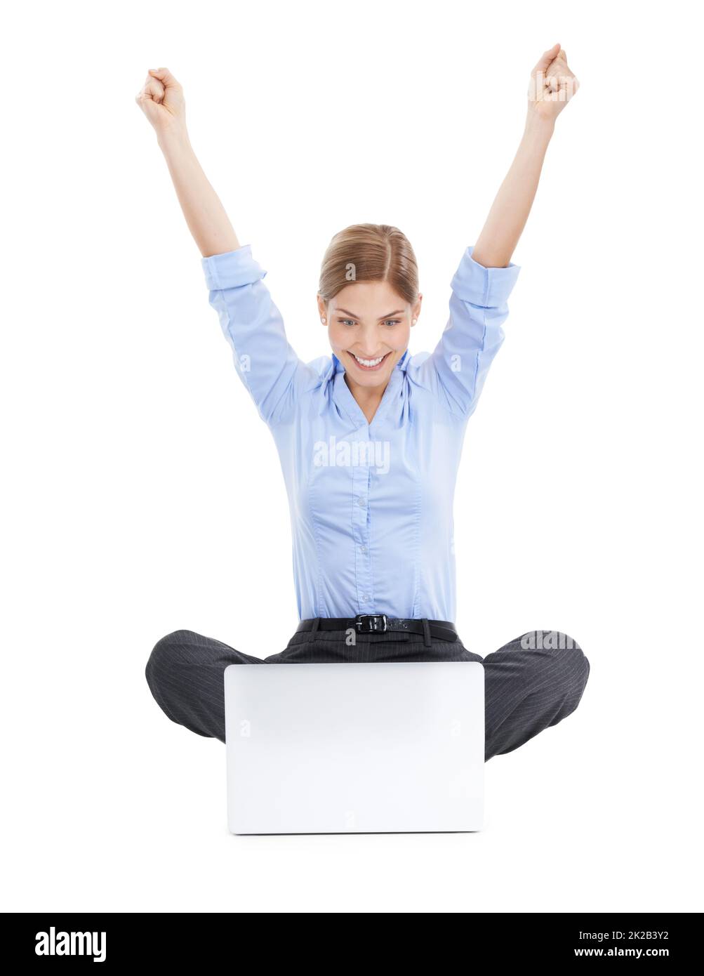 Better than ever before. Studio shot of a young businesswoman using her laptop on the floor and cheering in success against a white background. Stock Photo