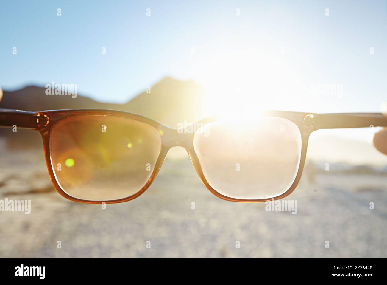 Looking at the bright side of life. POV shot of a person at the beach looking at the view through their sunglasses. Stock Photo