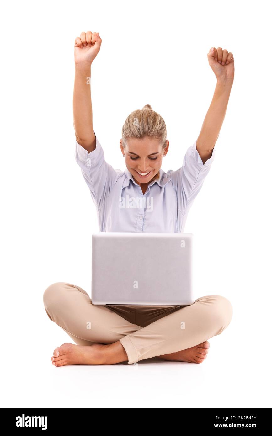 Success. An attractive young woman cheering while sitting in front of her laptop. Stock Photo