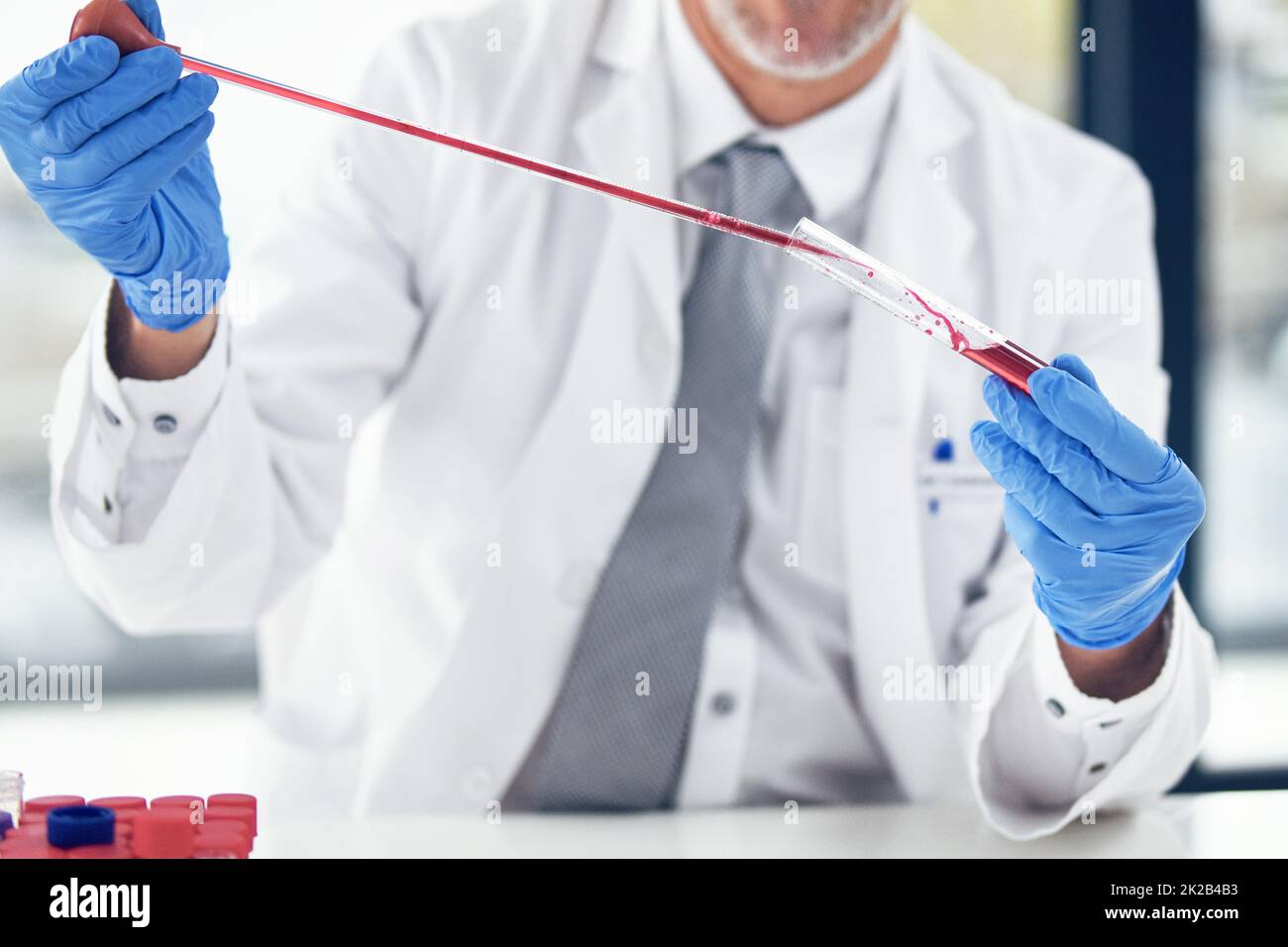 I can tell a lot from your blood. Cropped shot of a scientist conducting an experiment. Stock Photo