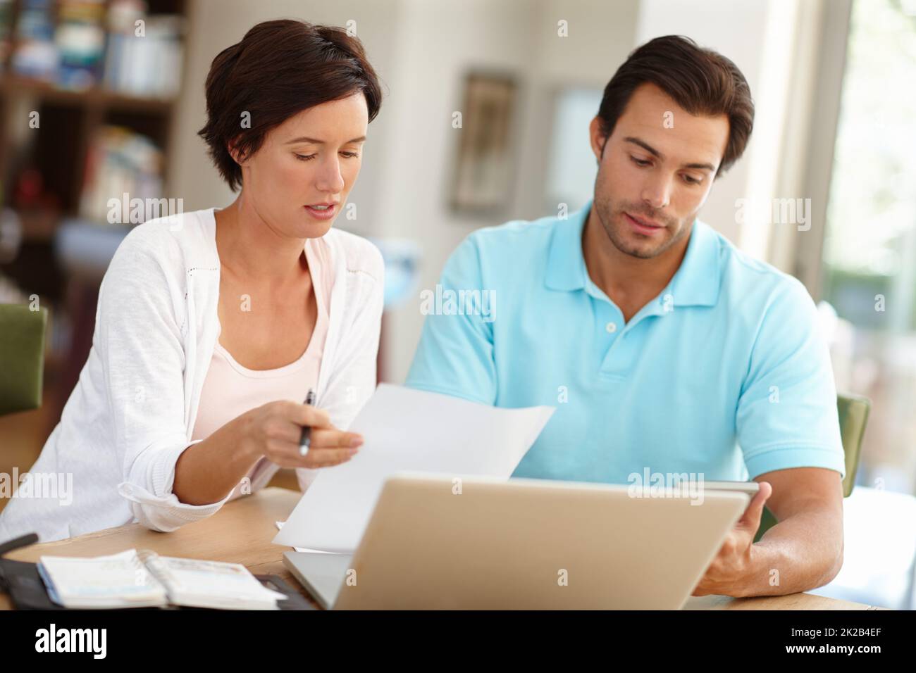 Reviewing their home finances. Shot of a couple sitting with a laptop busy doing budget calculations. Stock Photo