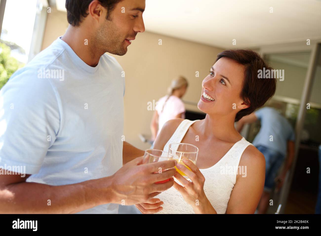 Enjoying each others company. Shot of a couple chatting while having a drink at a social gathering. Stock Photo