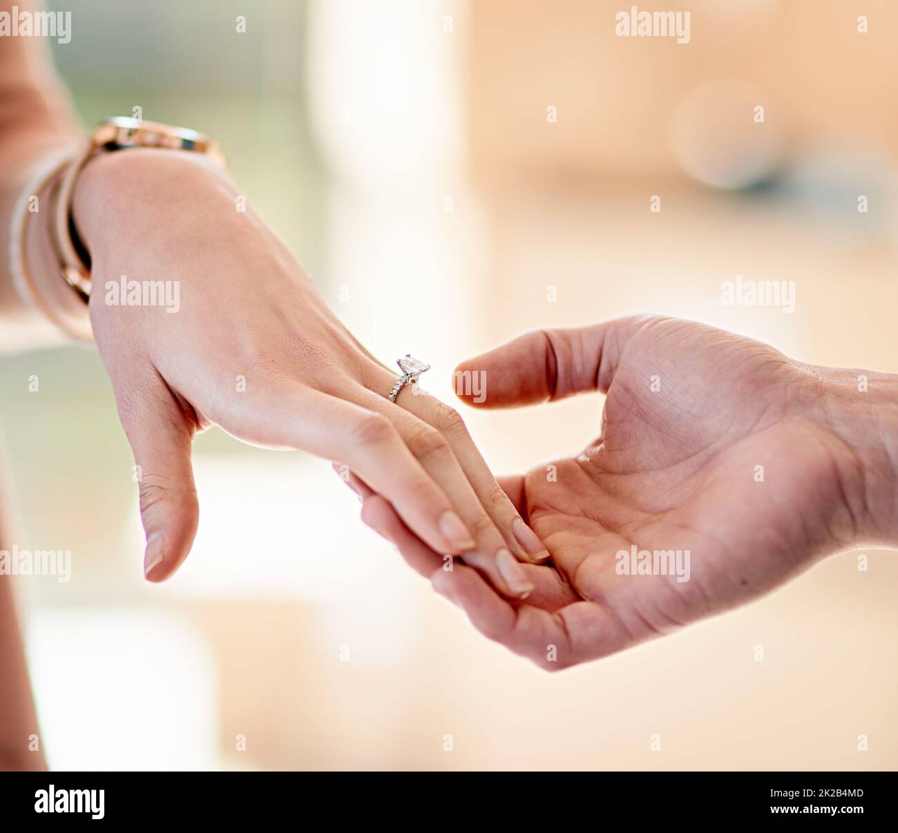 marking their true love closeup shot of a man putting an engagement ring onto his fiancees finger 2K2B4MD