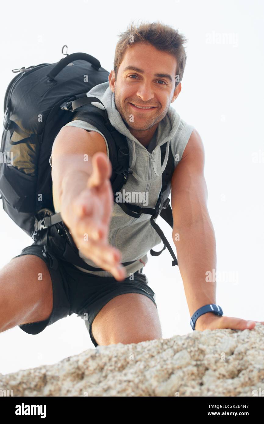 Let me give you a hand. Handsome young mountain climber extending his ...