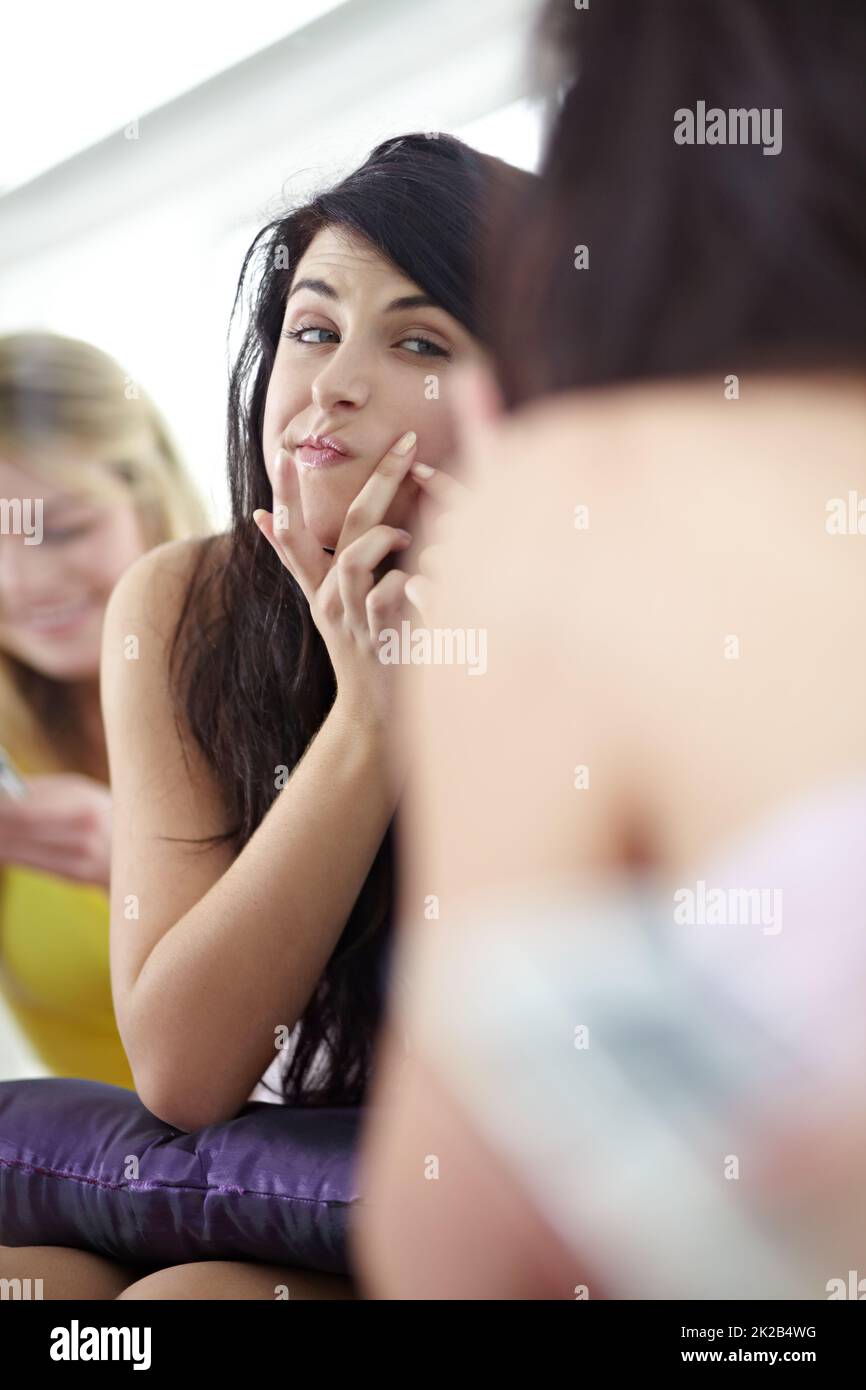 Oh no A zit. Attractive young woman picking at her skin in front of a mirror. Stock Photo