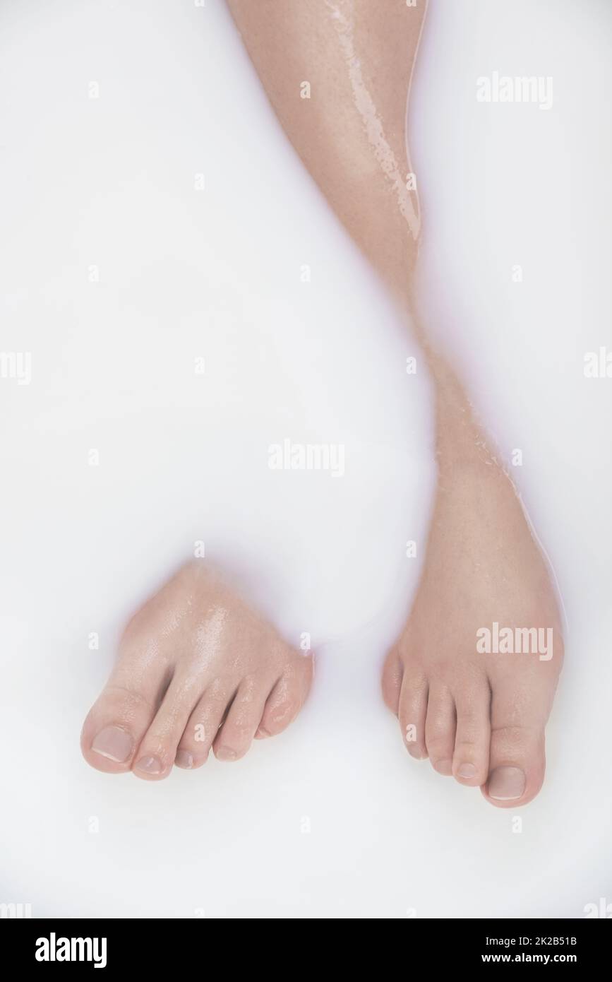Silky and milky. Cropped shot of a womans legs in a milky bath. Stock Photo