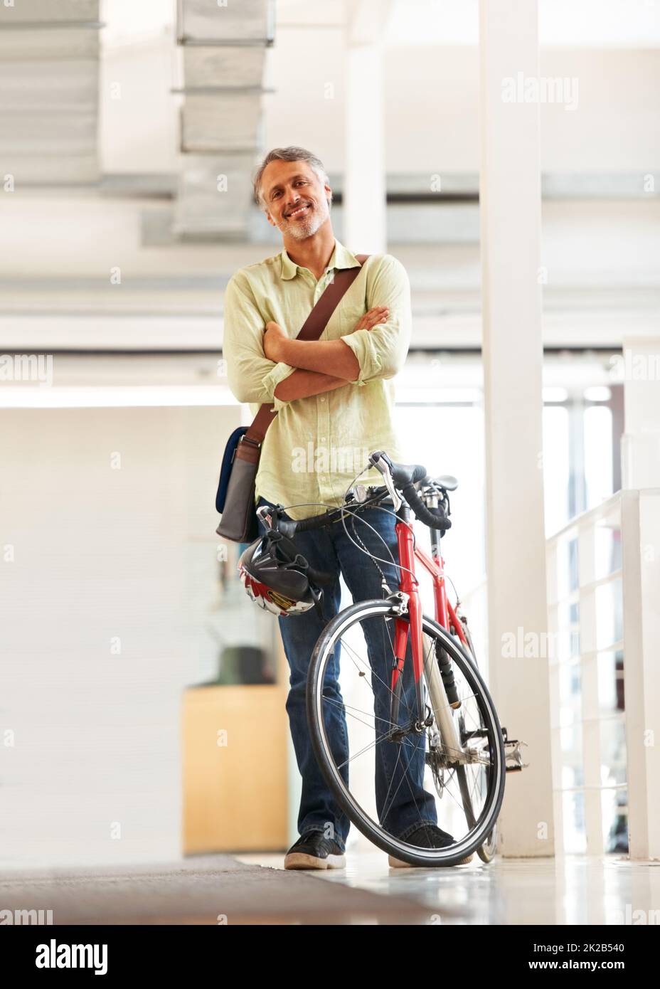 Making the days deliveries. Full length shot of a handsome bike messenger in an office. Stock Photo