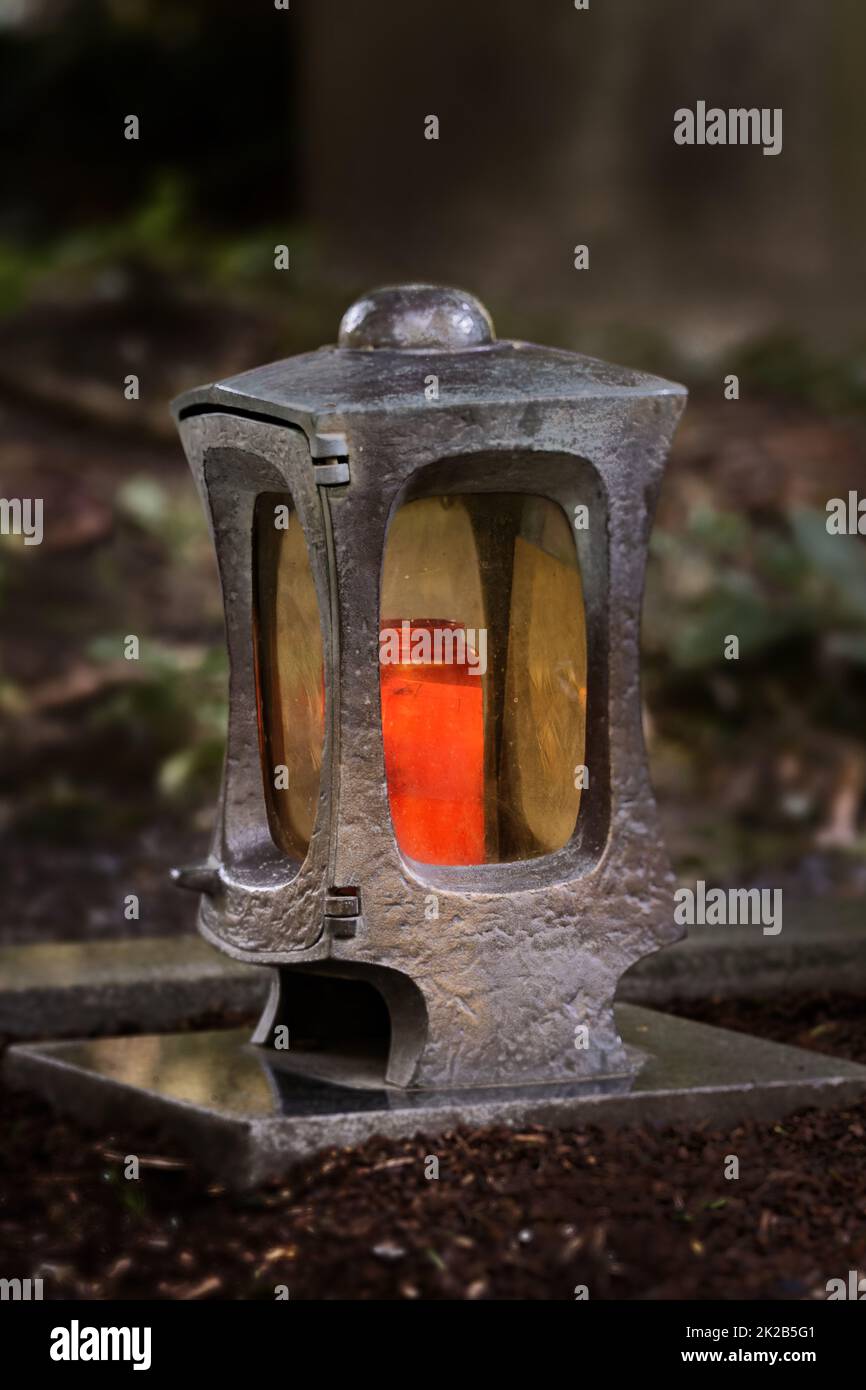 funeral lantern in a cemetery at dusk with a burning candle Stock Photo
