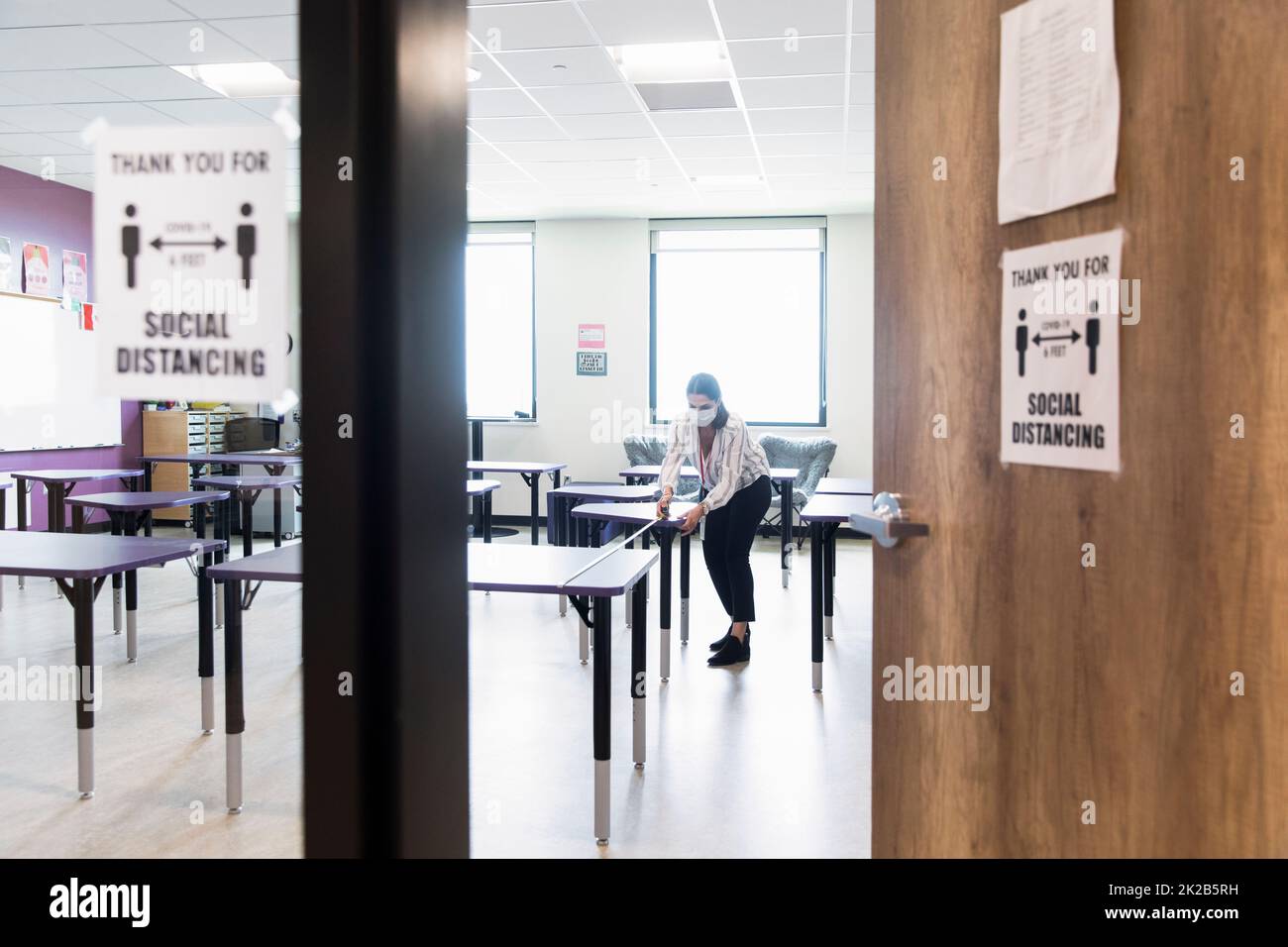 Teacher measuring distance between tables in class Stock Photo Alamy