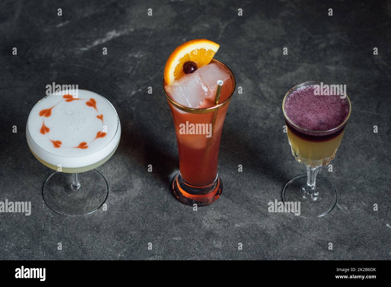 collection of three cocktails, whiskey sours, hearts drawn with bitters on egg white foam Stock Photo