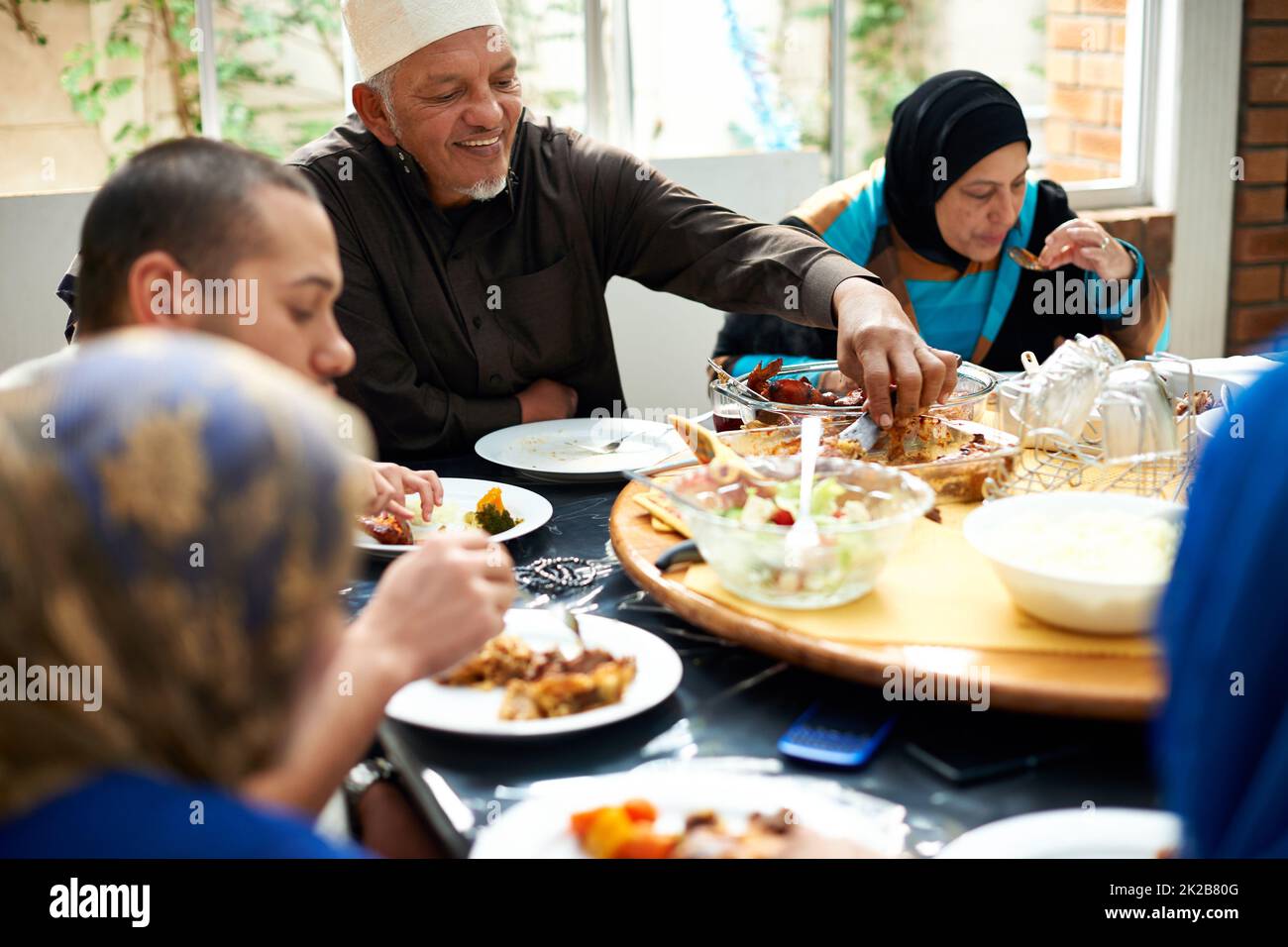 Food brings family together. Shot of a muslim family eating together. Stock Photo