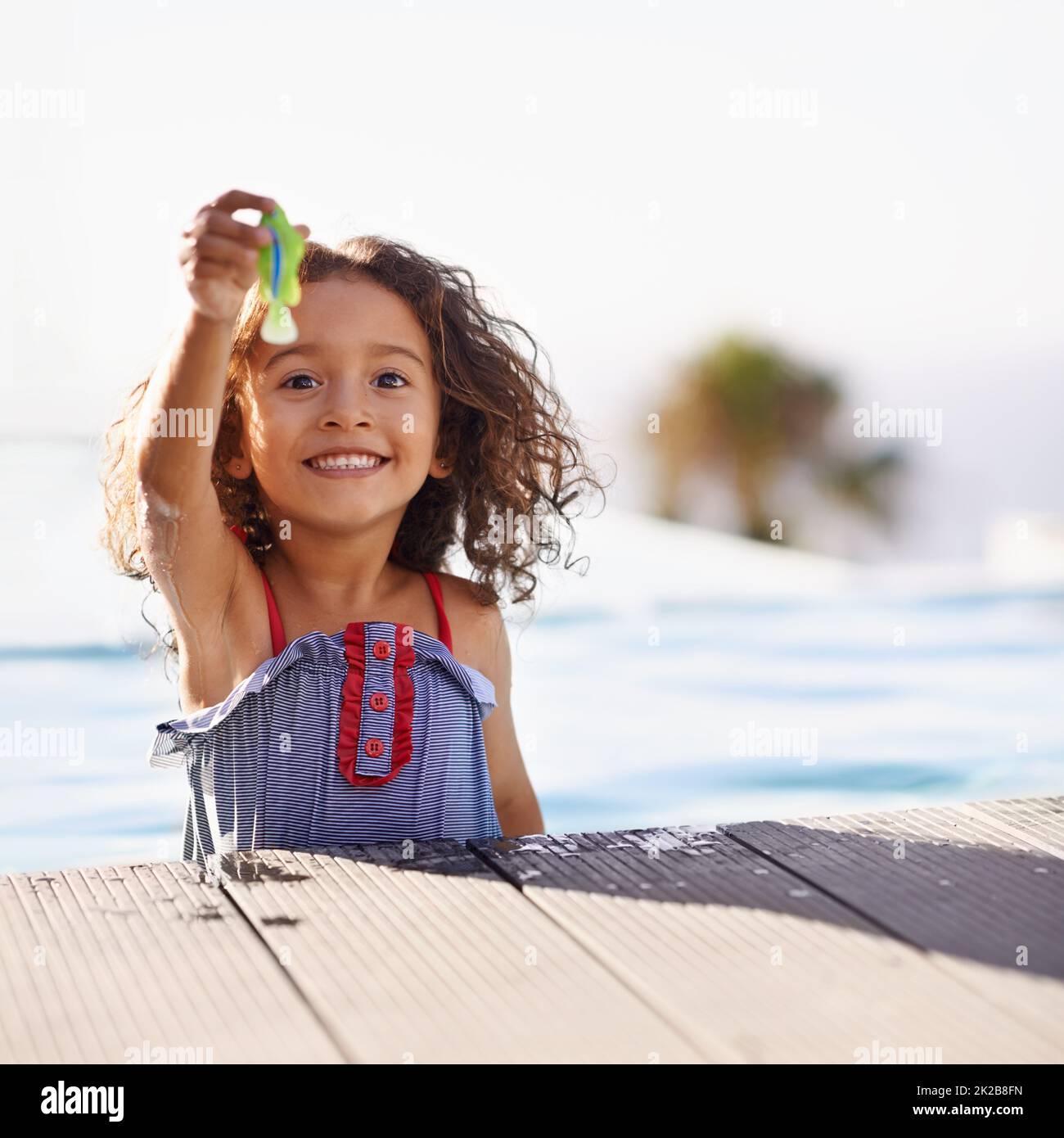 Splish Splash. Portrait of a happy little girl playing by the pool