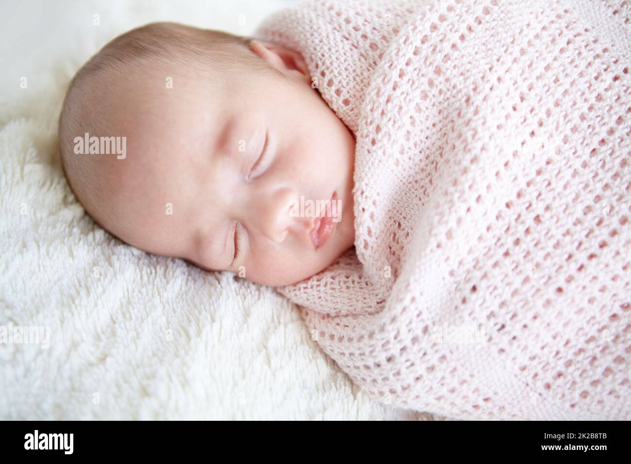 Sweet innocence. A beautiful infant girl sleeping while wrapped up in a